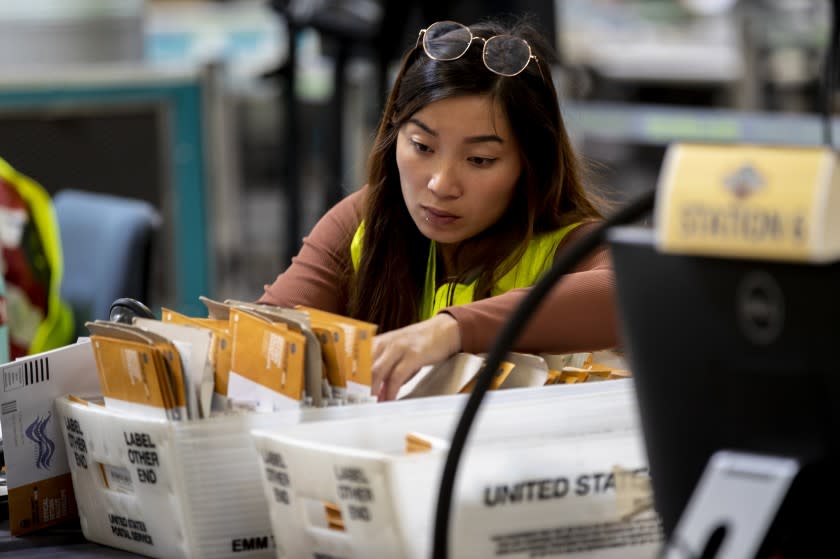 SANTA ANA, CA - September 14, 2021: An election worker verifies signatures on mail-in ballots on the day of the Recall election at the Orange County Registrar in Santa Ana, California.(Gina Ferazzi / Los Angeles Times)