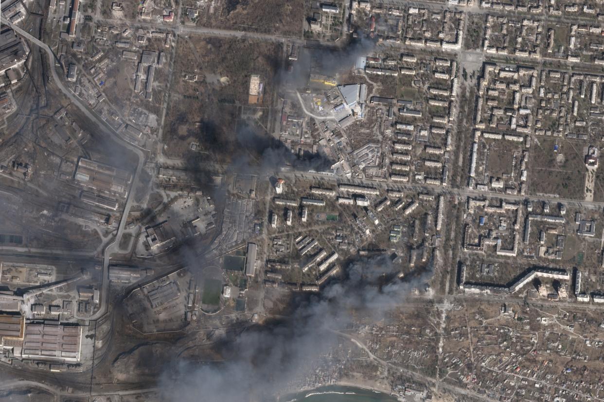 In this satellite photo from Planet Labs PBC, multiple civilian buildings burn amid Russian strikes on the Livoberezhnyi District of Mariupol, Ukraine, Sunday, March 20, 2022. (Planet Labs PBC via AP)