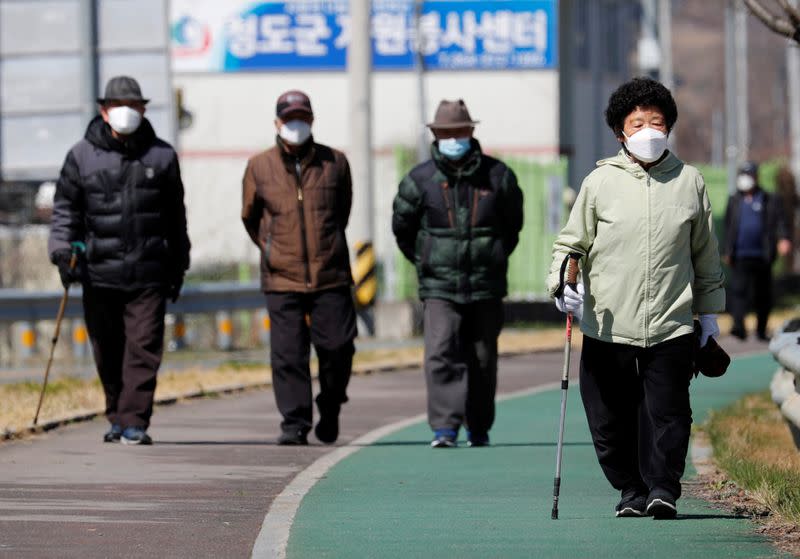 People wearing protective face masks following an outbreak of coronavirus disease (COVID-19), follow a trail in Cheongdo county