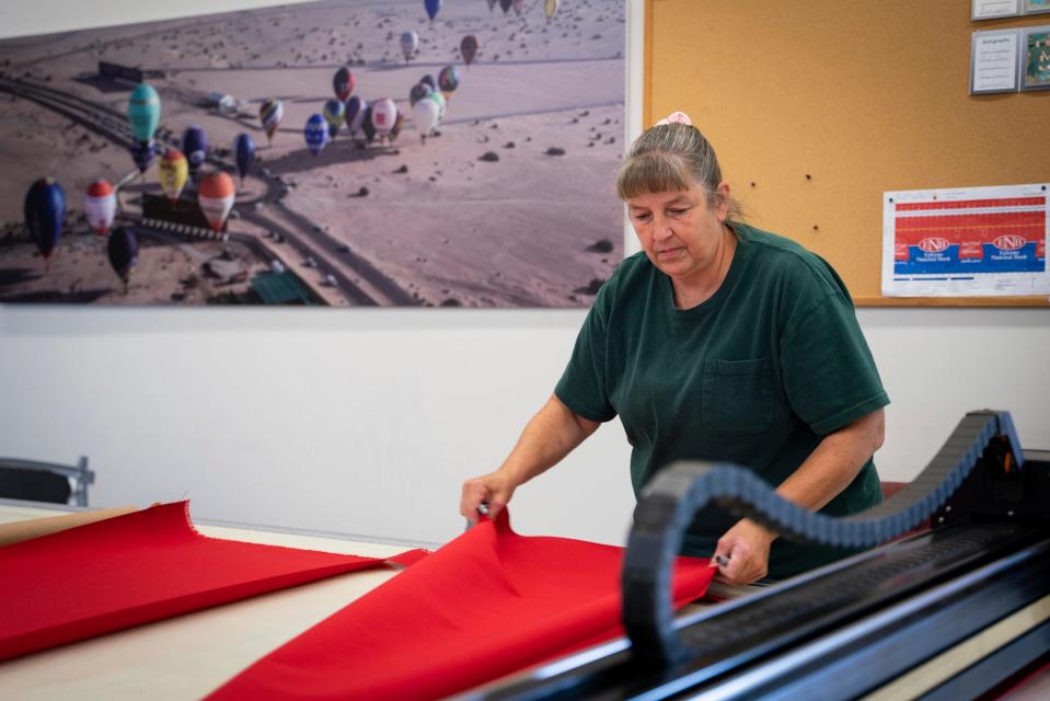 Theresa Wollet, 56, of Jackson, a cutting and pinning seamstress, who ordered roughly 30,000 yards of material to create the Alpha 5 Project hot air balloon, works at Cameron Balloons in Dexter on Friday, August 11, 2023.