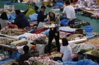 A family member of a missing passenger on board the capsized South Korean ferry Sewol carries breakfast while waiting for news from rescue and salvage teams, in a makeshift accommodation at a gymnasium in the port city of Jindo April 22, 2014. REUTERS/Issei Kato