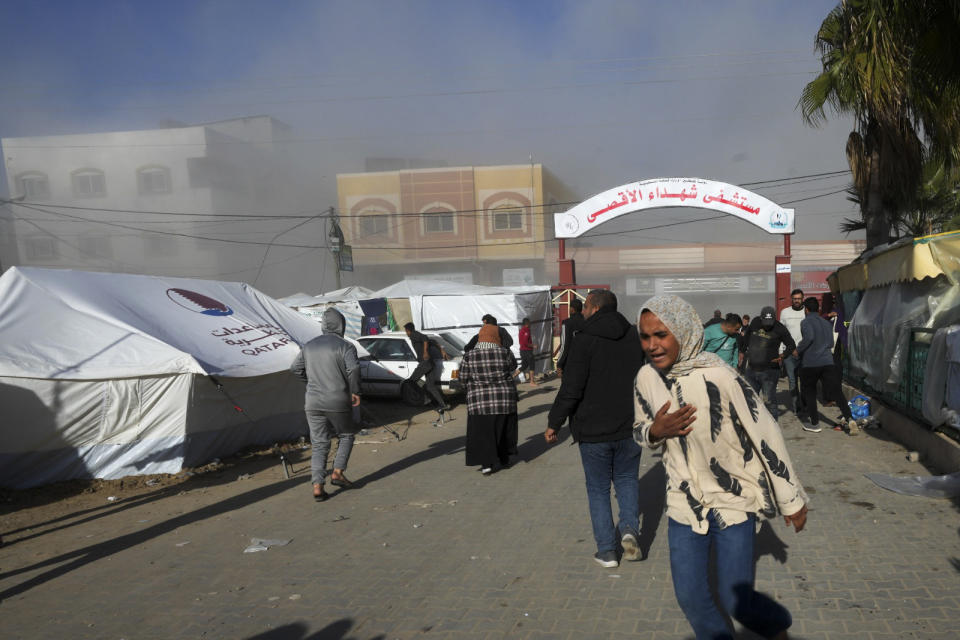 Palestinians run on the Al-Aqsa Hospital grounds moments after an Israeli strike hit a building next to it, in Deir al Balah, Gaza Strip, on Wednesday, Jan 10, 2023. (AP Photo/Adel Hana)