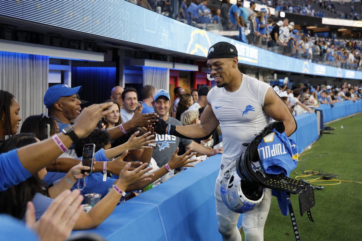 Amon-Ra St. Brown of the Detroit Lions high fives fans as he leaves the field after the game against the Los Angeles Chargers at SoFi Stadium on November 12, 2023 in Inglewood, California.