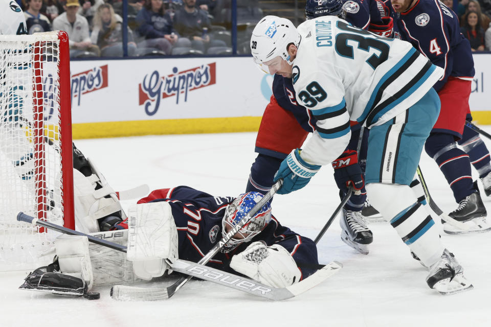 Columbus Blue Jackets' Joonas Korpisalo, left, makes a save against San Jose Sharks' Logan Couture during the first period of an NHL hockey game on Saturday, Jan. 21, 2023, in Columbus, Ohio. (AP Photo/Jay LaPrete)