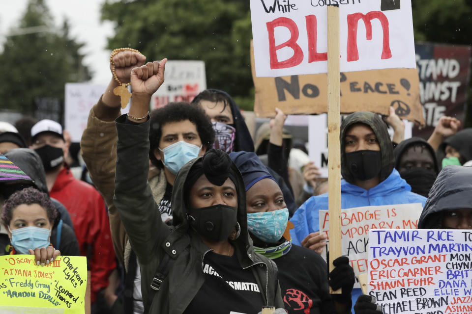 People raise their fists as they take part in a "Silent March" against racial inequality and police brutality that was organized by Black Lives Matter Seattle-King County, Friday, June 12, 2020, in Seattle. Hundreds of people marched for nearly two miles to support Black lives, oppose racism and to call for police reforms among other issues. (AP Photo/Ted S. Warren)