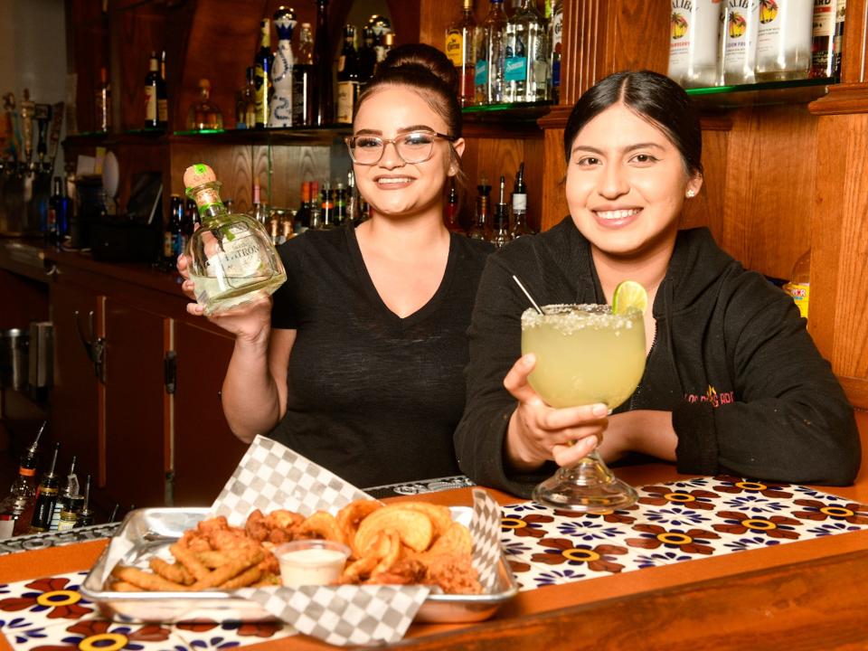 Shalynn Medina, left, and Jennifer Flores with appetizers and drinks from the Pollos Bros Bar. (James Quigg, for the Daily Press)