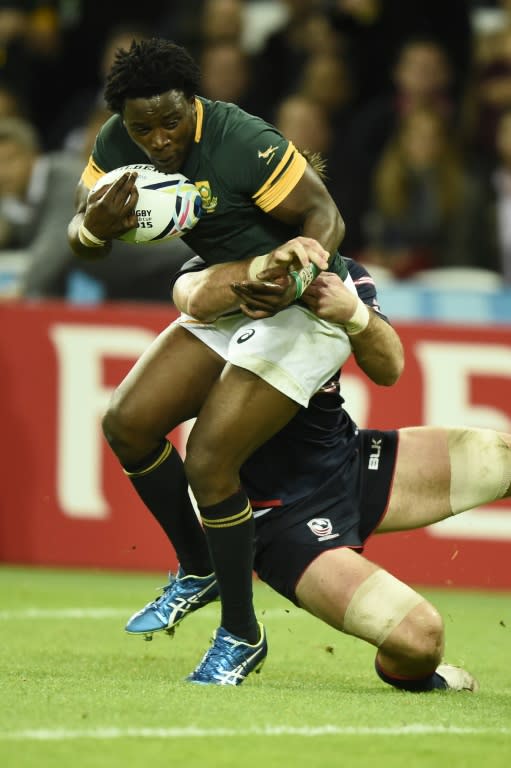 South Africa's wing Lwazi Mvovo (L) runs to score his team's tenth try despite a tackle by US back row forward Cameron Dolan (R) during a Pool B match of the 2015 Rugby World Cup at the Olympic Stadium, east London, on October 7, 2015