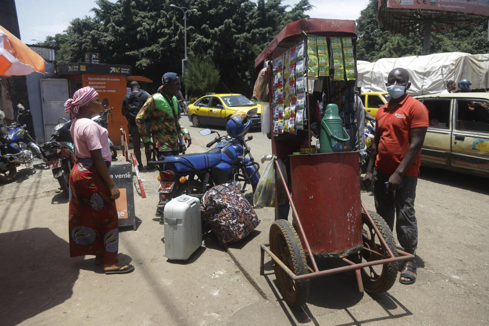 A man sells tea and coffee on a street in Conakry, Guinea, Thursday, Sept. 9, 2021. Guinea's new military leaders sought to tighten their grip on power after overthrowing President Alpha Conde, warning local officials that refusing to appear at a meeting convened Monday would be considered an act of rebellion against the junta. (AP Photo/ Sunday Alamba)