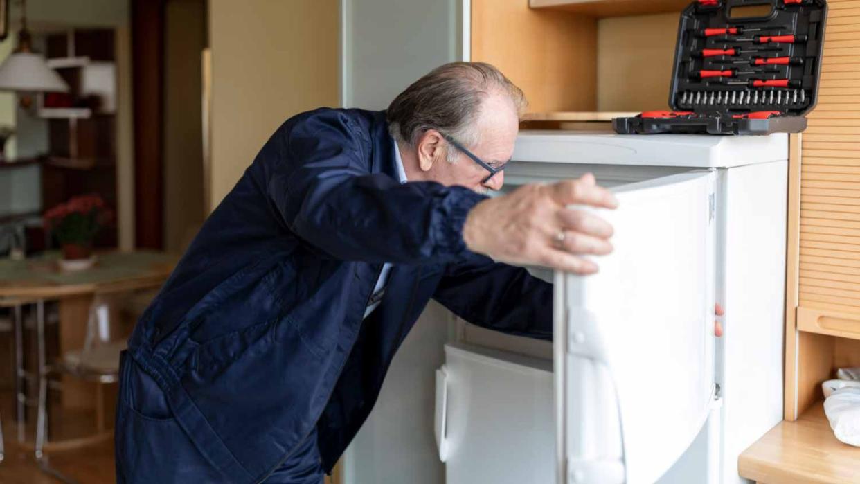 Man repairing a refrigerator