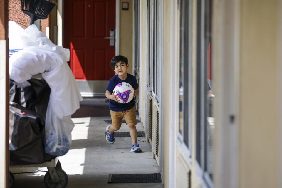 Mojib Khan plays outside the hotel room where he and his brother Zabih Khan are living after fleeing Afghanistan.