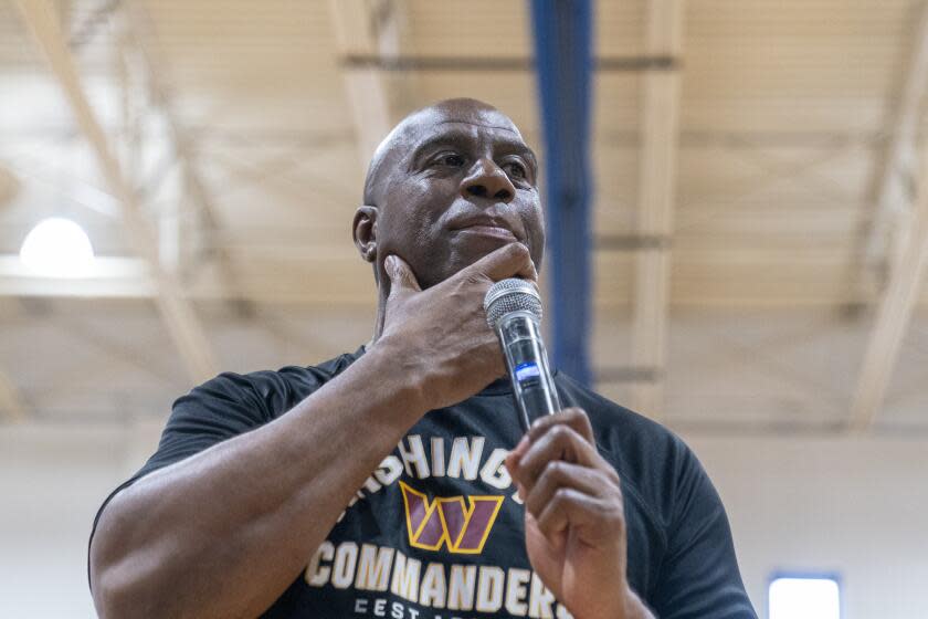 Washington Commanders part-owner Magic Johnson pauses while speaking at the Boys & Girls Club of Greater Washington