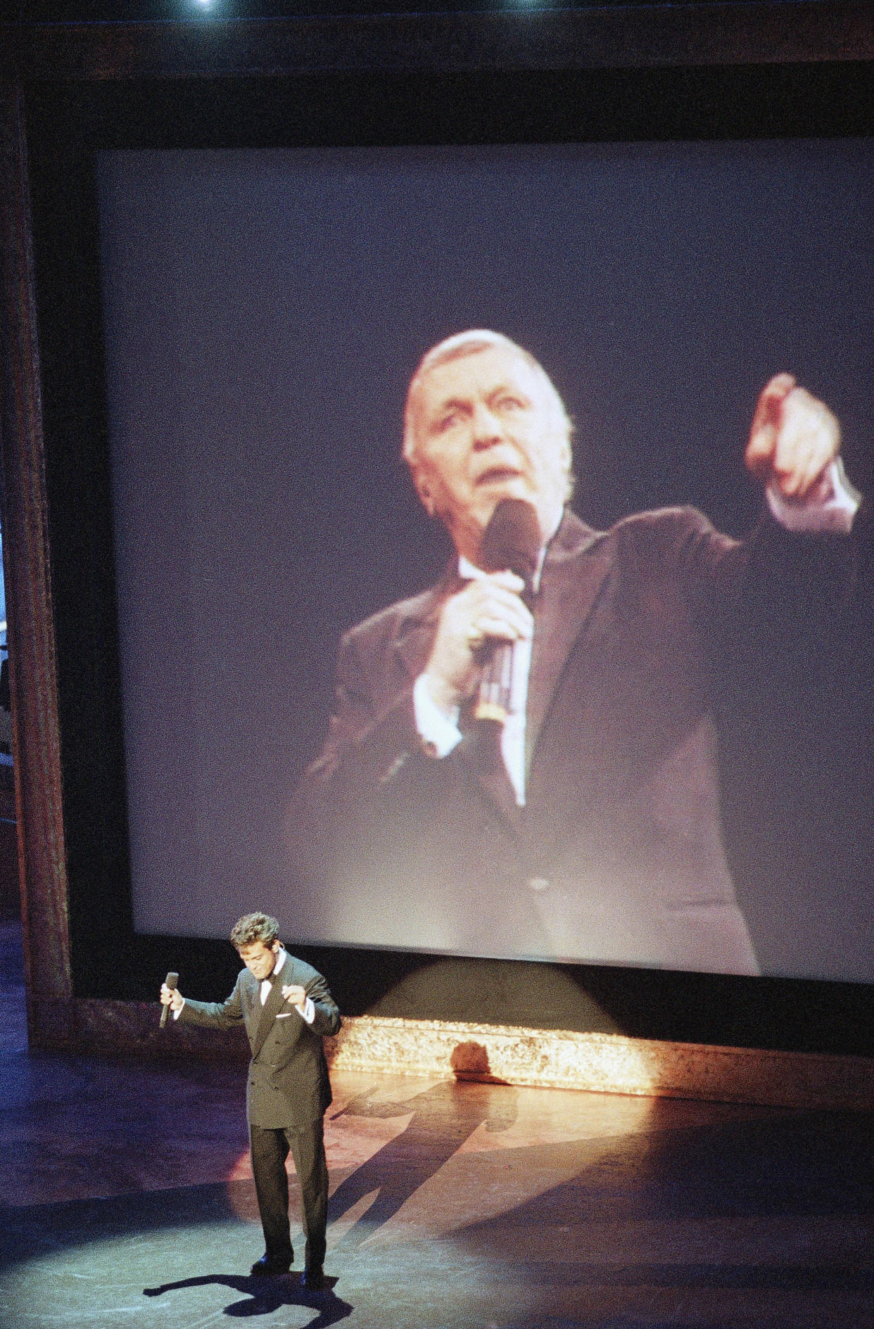 El cantante mexicano Luis Miguel canta a dueto “Come Fly With Me” con un video de Frank Sinatra, durante el homenaje que rindieron al emblemático cantante el 19 de noviembre de 1995 en el Auditorio Shrine en Los Angeles. (AP)