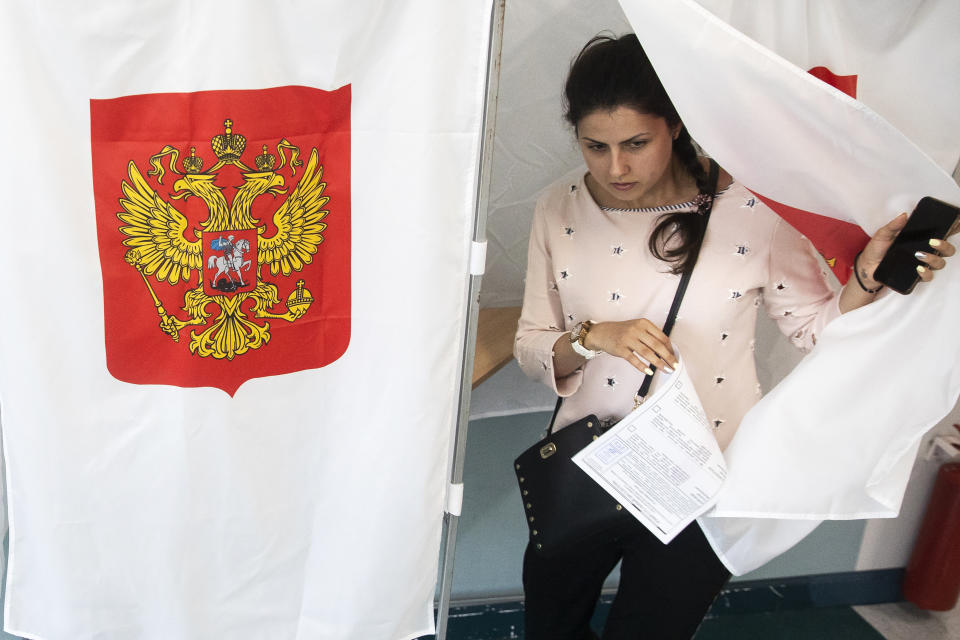 A woman exits a polling booth before casting at a polling station during a city council election in Moscow, Russia, Sunday, Sept. 8, 2019. Residents of Russia's capital are voting in a city council election that is shadowed by a wave of protests that saw the biggest demonstrator turnout in seven years and a notably violent police response. (AP Photo/Pavel Golovkin)