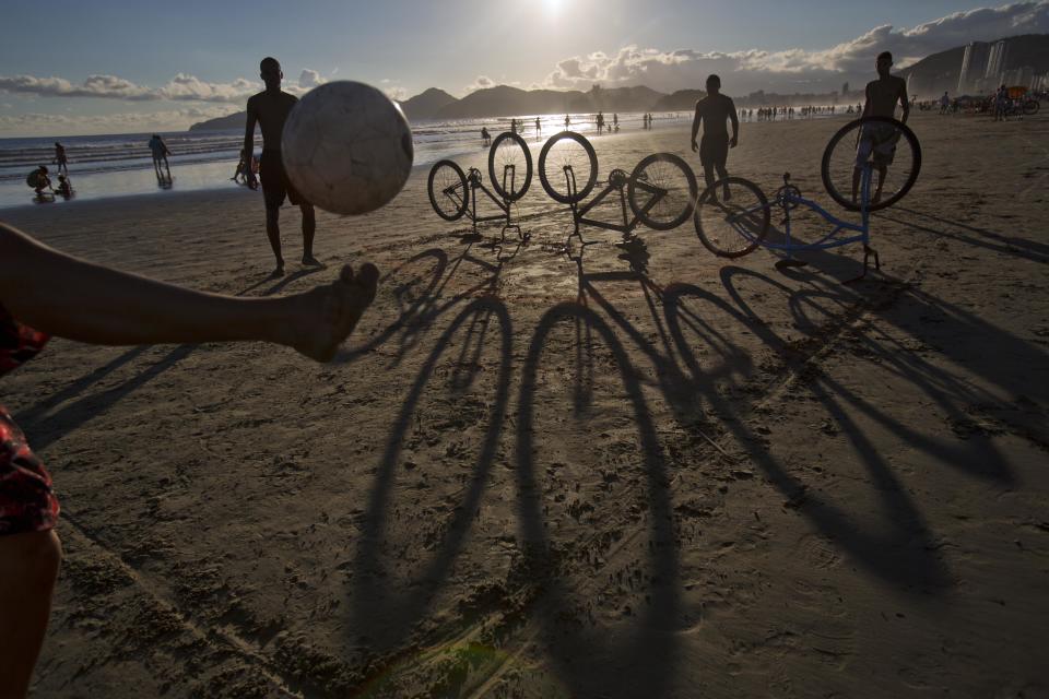 Using bicycles as a "net", kicking a ball back and forth at the beach Santos, Brazil. (David Guttenfelder/AP Images for The New York Times Magazine)