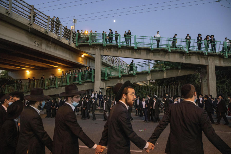 FILE - Ultra orthodox Jews dance as they block a highway during a protest against the detention of a member of their community who refuses to serve military service in Bnei Brak, Israel, Sunday, Dec. 27, 2020. With ultra-Orthodox parties now wielding unprecedented power and playing a key role in a contentious plan to overhaul the legal system, they are aggravating concerns among secular Israelis that the character and future of their country is under threat. (AP Photo/Ariel Schalit, File)