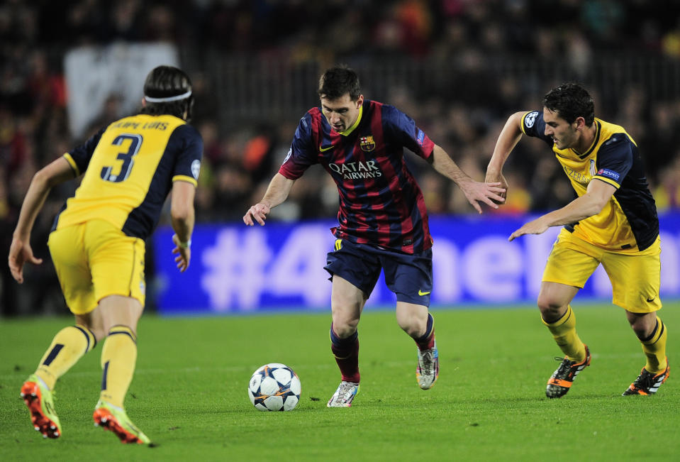 Barcelona's Lionel Messi, centre tries to get past Atletico's Filipe Luis, left and Oliver Torres during a first leg quarterfinal Champions League soccer match between Barcelona and Atletico Madrid at the Camp Nou stadium in Barcelona, Spain, Tuesday April 1, 2014. (AP Photo/Manu Fernandez)