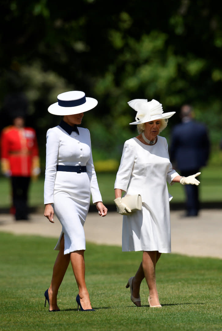 Was trägt man zum Nachmittagstee mit der Queen? Melania Trump und die Herzogin von Cornwall hatten überraschend ähnliche Outfits gewählt: Die First Lady trug ein schickes langärmeliges Kleid von Dolce & Gabbana in Weiß und Marineblau. Sie vervollständigte das Ensemble mit einem königlichen maßgeschneiderten Hut von Hervé Pierre.<em> [Foto: Getty]</em>
