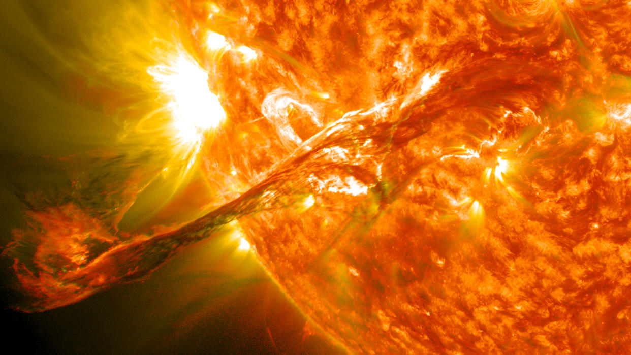  Closeup of a powerful eruption fro the sun's orange-yellow surface. 