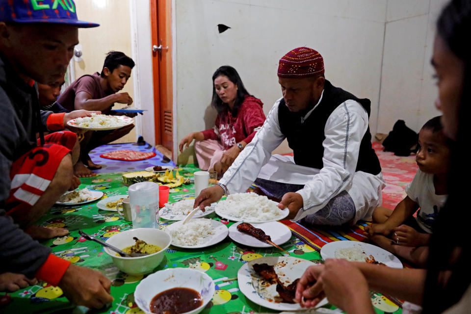 Mohammad Ali Acampong, 42, and his family break their fast with rice, chicken and pineapples during Ramadan in their temporary shelter in Marawi City, Lanao del Sur province, Philippines. (Photo: Eloisa Lopez/Reuters)