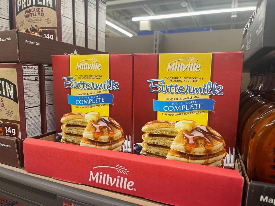 Two red and yellow boxes of pancake mix in a display