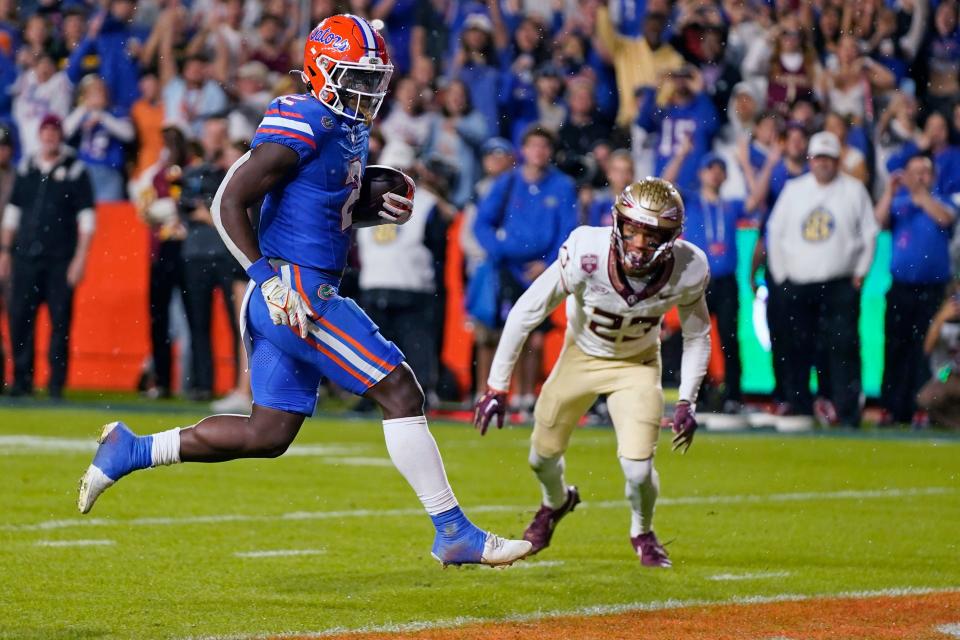 Florida running back Montrell Johnson Jr., left, runs past Florida State defensive back Fentrell Cypress II (23) for a 5-yard touchdown during the first half of an NCAA college football game Saturday, Nov. 25, 2023, in Gainesville, Fla. (AP Photo/John Raoux)