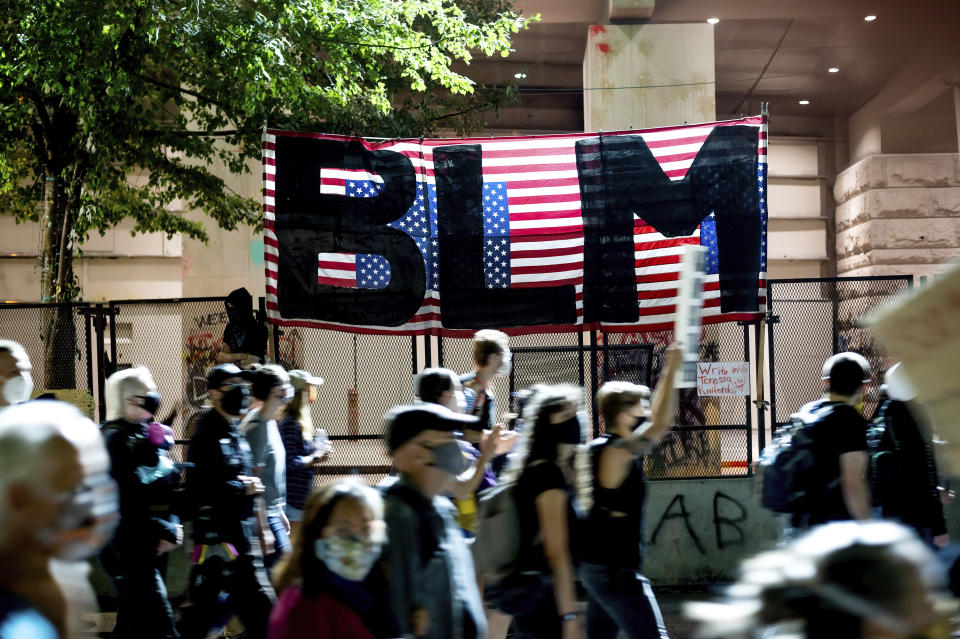 FILE - In this July 31, 2020, file photo, Black Lives Matter protesters march past the Mark O. Hatfield United States Courthouse in Portland, Ore. More than two months of sustained, intense protests in Portland, Oregon, one of the whitest major cities in America, have captured the world's attention and put a city that's less than 6% Black at the heart of the conversation about police brutality and racism. (AP Photo/Noah Berger, File)