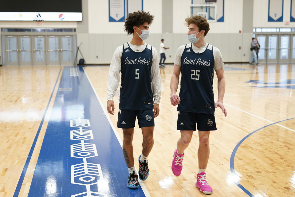 St. Peter's Daryl Banks III, left, and Doug Edert talk while warming-up for NCAA college basketball practice in Jersey City, N.J., Tuesday, March 22, 2022. (AP Photo/Seth Wenig)