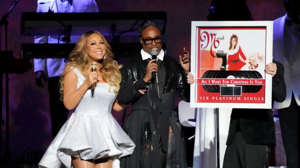 mariah carey smiling next to a plaque showcasing her christmas record