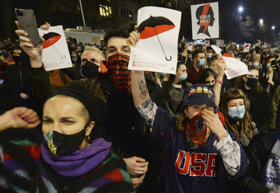 A crowd gathers outside the house of Poland's ruling conservative party leader Jaroslaw Kaczynski in Warsaw, Poland, Friday, Oct. 23, 2020. Protesters vented anger for a second day across Poland over a court ruling that declared abortions of fetuses with congenital defects unconstitutional. The hundreds of protesters who gathered in many cities defied a COVID-19-related ban on gatherings that was imposed nationwide on Friday. (AP Photo/Czarek Sokolowski)