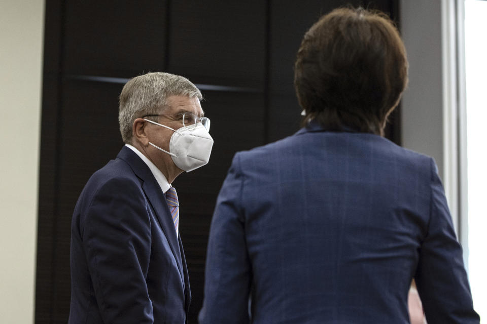 IOC President Thomas Bach, left, is greeted by Tokyo 2020 President Seiko Hashimoto, right, during their meeting at the Tokyo 2020 Headquarters Tuesday, July 13, 2021 in Tokyo, Japan. Bach has appeared in public for the first time since arriving in Tokyo with the pandemic-postponed Olympics opening in just 10 days.(Takashi Aoyama/Pool Photo via AP)