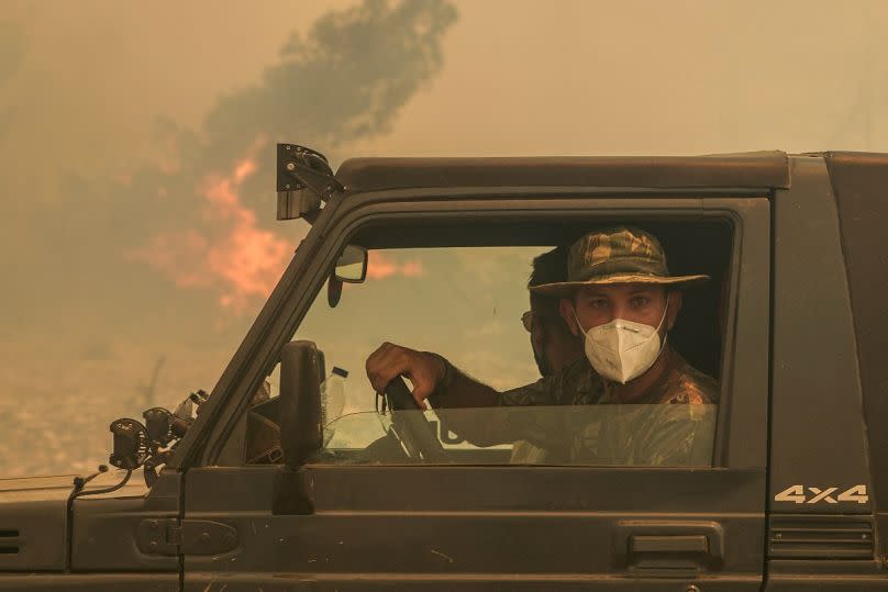 Military personnel pass a wildfire in Vati village, on the island of Rhodes, in July 2023