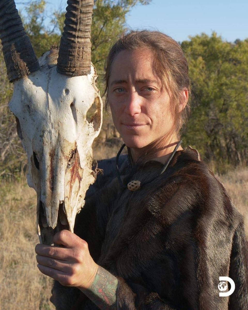 Cheeny Plante, of Sanford, Maine, holds up the skull of an oryx that she found near the shelter she built for her challenging stay in a South African desert for a spinoff season of the hit TV show, "Naked and Afraid."