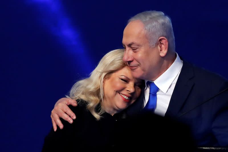 Israeli Prime Minister Benjamin Netanyahu hugs his wife Sara as they react following the announcement of exit polls in Israel's election at his Likud party headquarters in Tel Aviv