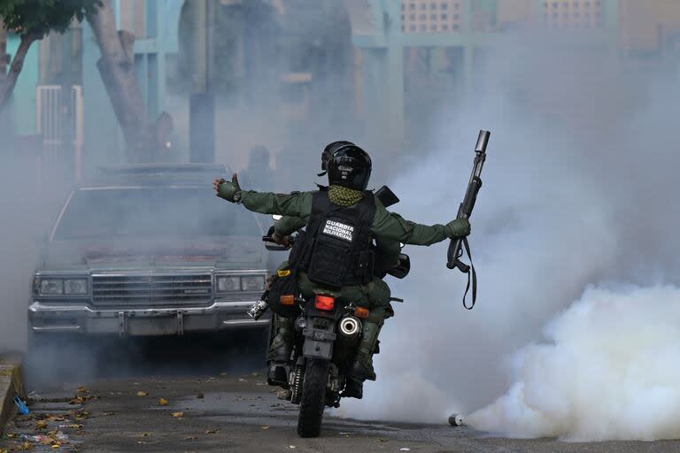 Miembros de la Guardia Nacional lanzan gases lacrimógenos contra manifestantes opositores en el barrio caraqueño de Chacao