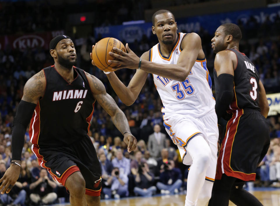 Oklahoma City Thunder forward Kevin Durant (35) drives between Miami Heat forward LeBron James (6) and guard Dwyane Wade (3) during the fourth quarter of an NBA basketball game in Oklahoma City, Thursday, Feb. 20, 2014. Miami won 103-81. (AP Photo/Sue Ogrocki)