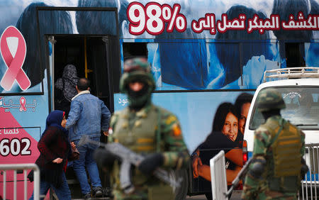 People get on a bus as special forces soldiers guard the National Election Authority, which is in charge of supervising the 2018 presidential election in Cairo, Egypt, January 24, 2018. REUTERS/Amr Abdallah Dalsh