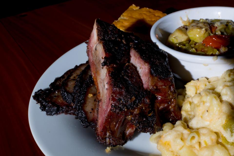 Award winning beef brisket is prepared with a slice of cornbread and a side of green Chile Mac and cheese at barbecue restaurant Hallelujah BBQ at 130-A N. Cotton.