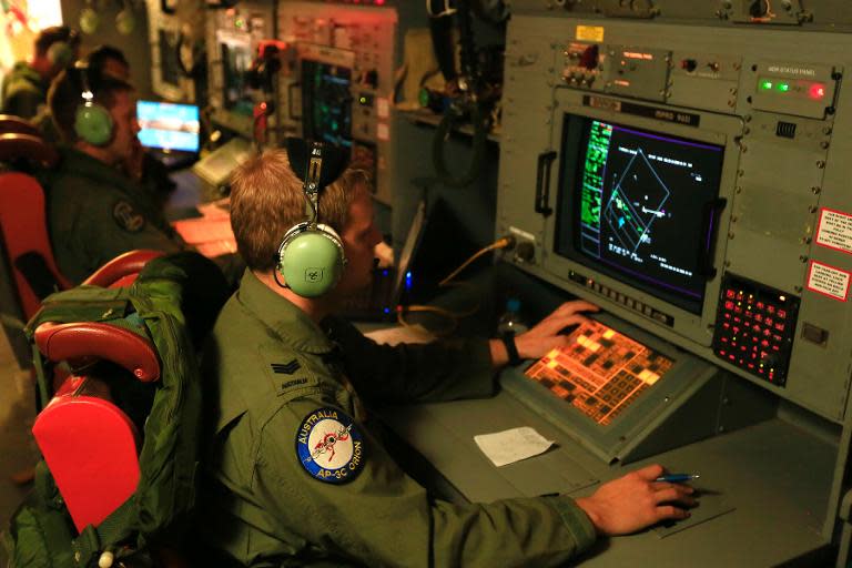 This Australian Defence handout photo taken on April 1, 2014 shows crew members at work onboard a RAAF Orion during the search for missing Malaysia Airlines flight MH370 in the southern Indian Ocean