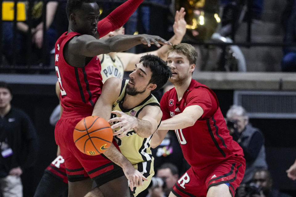 Purdue guard Ethan Morton (25) makes a pass between Rutgers forward Mawot Mag (3) and guard Cam Spencer (10) during the first half of an NCAA college basketball game in West Lafayette, Ind., Monday, Jan. 2, 2023. (AP Photo/Michael Conroy)