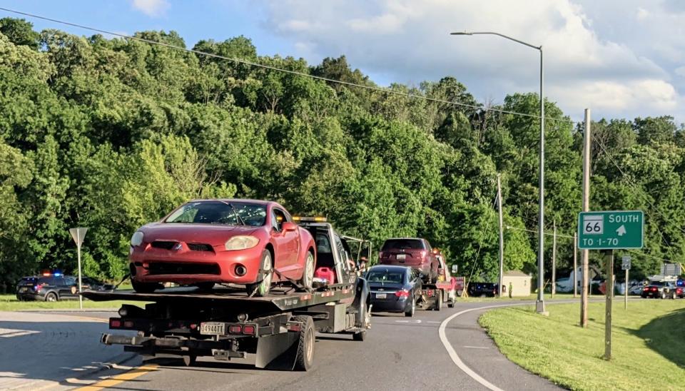 Three vehicles, including a Mitsubishi Eclipse with a damaged windshield, are hauled away from the scene of a shooting  on Mapleville Road near Smithsburg, Md., on Thursday, June 9, 2022.