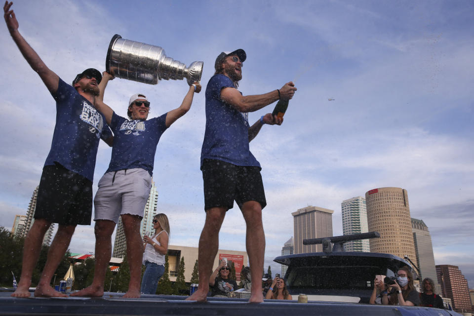 Tampa Bay Lightning' Steven Stamkos, Luke Shenn and Victor Hedman spray Champagne while Shenn holds the Stanley Cup during the NHL hockey Stanley Cup champions' boat parade, Wednesday, Sept. 30, 2020, in Tampa, Fla. (Dirk Shadd/Tampa Bay Times via AP)