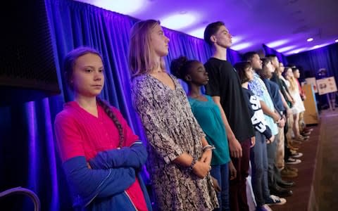 Greta Thunberg, left, is joined by other child petitioners to announce a complaint they will file before the United Nations  - Credit: AP Photo/Mark Lennihan