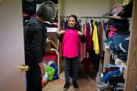 Annarut Hernandez, 10, a refugee from Honduras, looks for clothes with volunteer Guadalupe Gallardo at the church hall of the Basilica of San Albino in Mesilla, New Mexico