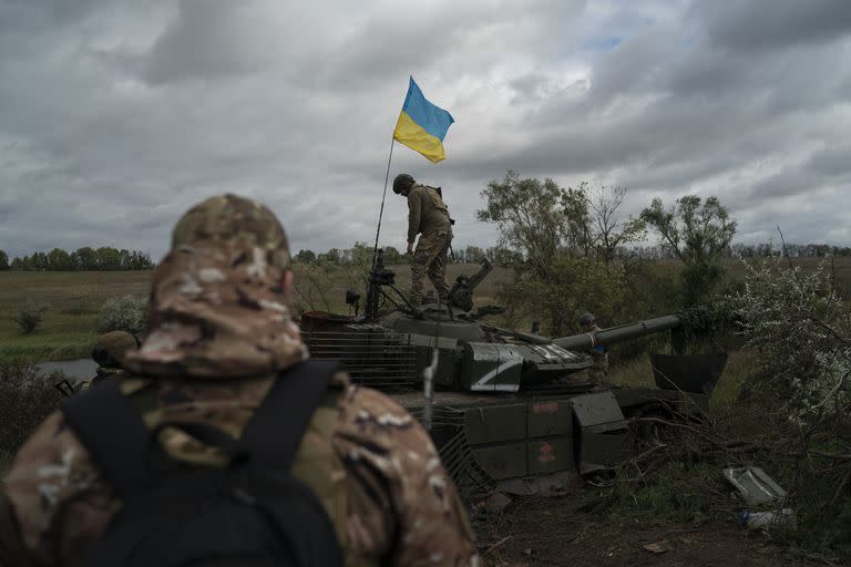 Un soldado de la guardia nacional ucraniana se posa sobre un tanque ruso destruido en una zona cercana a la frontera con Rusia, en la región de Kharkiv, Ucrania, el lunes 19 de septiembre de 2022. 
