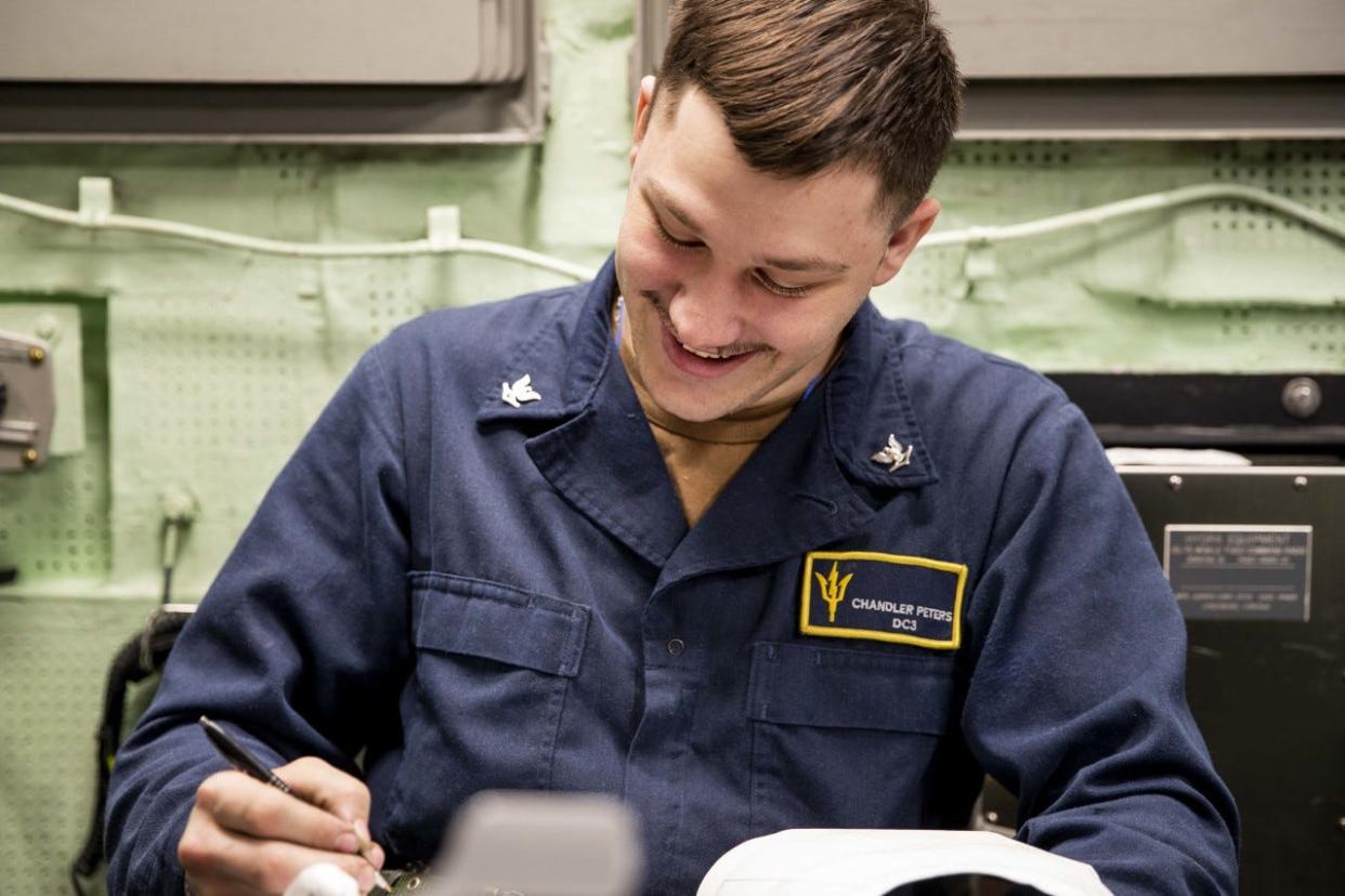 U.S. Navy Damage Controlman 3rd Class Chandler Peters, from Uhrichsville, makes a log entry in the central control station aboard amphibious assault carrier USS Tripoli on Saturday. Tripoli is underway conducting routine operations in U.S. 3rd Fleet.