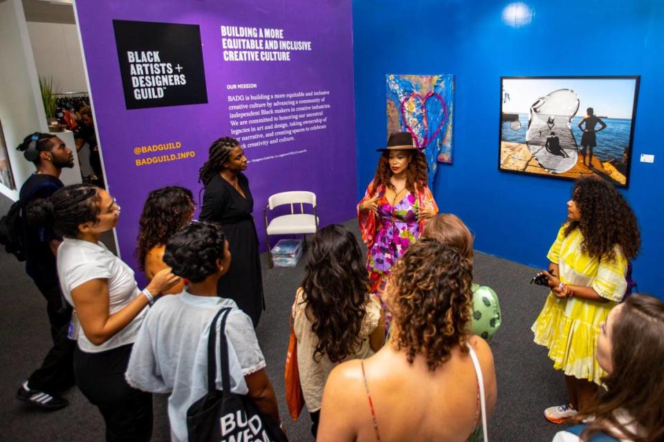 Artist Alicia Bailey, right, speaks to visitors on a guided tour by Fair director Mikhaile Solomon, left, at the Art Prizm Fair.