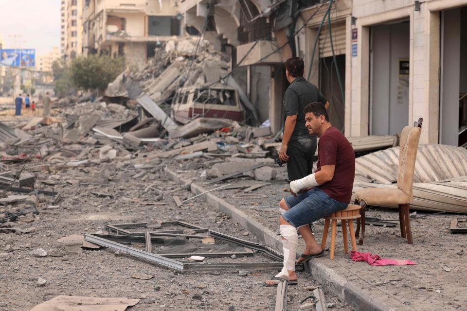 October 10, 2023: Palestinian men look at the destruction outside a damaged apartment building following Israeli airstrikes on Gaza City. Israel kept up its deadly bombardment of Hamas-controlled Gaza on October 10 after the Palestinian militant group threatened to execute some of the around 150 hostages it abducted in a weekend assault if air strikes continued without warning.