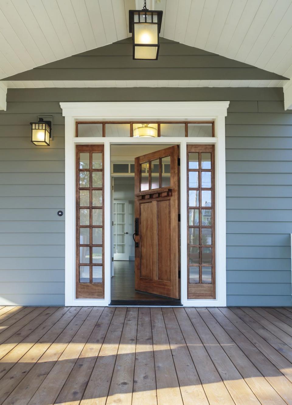 front porch of blue gray house with open front door