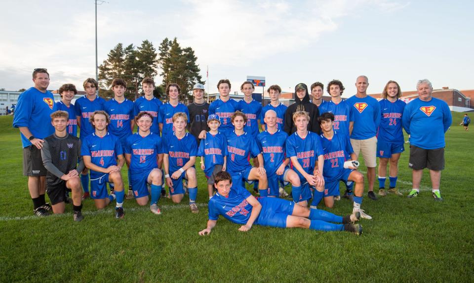 Honorary Winnacunnet High School boys soccer captain Evan Austin (center) posed with the team after its 2-1 win over Londonderry last October.