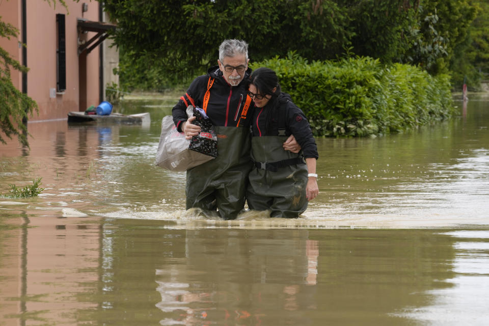 FILE - A couple walk through a flooded road of Lugo, Italy, May 18, 2023. The floods that sent rivers of mud tearing through towns in Italy’s northeast are another soggy dose of climate change's all-or-nothing weather extremes, something that has been happening around the globe, scientists say. (AP Photo/Luca Bruno, File)